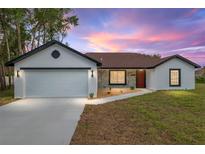 Charming single-story home featuring a red front door, stone accents and an attached two-car garage at 6240 Cherry Rd, Ocala, FL 34472