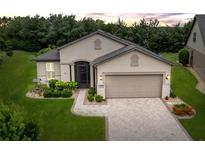 Charming single-story home featuring a manicured lawn, paver driveway, and neutral stucco exterior at 7839 Sw 97Th Cir, Ocala, FL 34481
