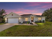 Charming single-story home with a well-manicured lawn and inviting curb appeal at dusk at 9957 Sw 45Th Ave, Ocala, FL 34476