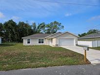 Charming single-story home with a well-manicured lawn and attached two-car garage at 11 Larch Course Ter, Ocala, FL 34480