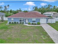 Charming single-story home with a well-maintained lawn and inviting curb appeal, featuring a long driveway and attached garage at 14762 Sw 22Nd Court Rd, Ocala, FL 34473