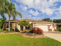 Charming single-story home features stone accents, a well-manicured lawn, mature palms and appealing landscaping at 1953 Hartford Path, The Villages, FL 32162