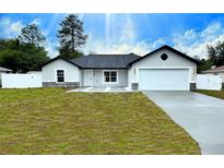 Charming single-story home with a well-manicured lawn and a two-car garage, located in a quiet neighborhood at 28 Hemlock Circle Pass, Ocala, FL 34472