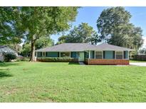 Charming single-story home with a well-manicured lawn, mature trees, and appealing blue exterior at 2855 Se 38Th St, Ocala, FL 34480
