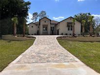 Stunning single-Gathering home featuring a stone facade, manicured lawn, and a brick driveway leading to the residence at 5034 Nw 75Th Ave, Ocala, FL 34482