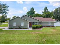 Charming single-story home with a well-maintained lawn, a neatly landscaped yard, and a welcoming front entrance at 5390 Se 15Th Ct, Ocala, FL 34480