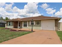Charming single-story home featuring a large front yard and a two-car garage, enhanced by an inviting facade at 7 Pecan Drive Loop, Ocala, FL 34472