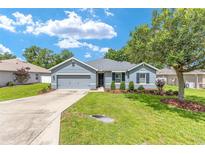 Charming single-story home featuring a well-manicured lawn and an attached two-car garage at 7054 Sw 64Th Ter, Ocala, FL 34476