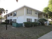 Inviting two-story condo featuring neutral siding, green shutters, well-maintained landscaping, and classic architectural details at 8134 Fairways Cir # R203, Ocala, FL 34472