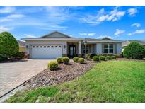 Charming single-story home featuring a well-manicured lawn and a brick-paved driveway at 8640 Sw 83Rd Loop, Ocala, FL 34481