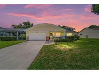 Charming single Gathering home with manicured front lawn under a beautiful pink and purple sky at 8704 Sw 94Th Ln # G, Ocala, FL 34481