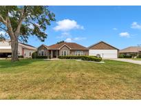 Charming brick home with manicured lawn and mature landscaping on a sunny day at 9641 Se 70Th Ter, Ocala, FL 34472