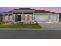 Charming home featuring a three-car garage and stylish blue accents on the front facade at 10045 Sw 82Nd Place Rd, Ocala, FL 34481