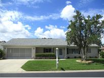 Charming single-story home featuring a well-maintained lawn and a mature tree providing shade at 11470 Sw 139Th St, Dunnellon, FL 34432