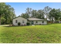 Charming single-story home with a well-maintained lawn and classic green trim at 12681 Se 54Th Ave, Belleview, FL 34420