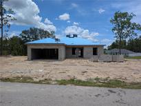 Unfinished concrete block home with blue roofing being built in a sunny, undeveloped neighborhood at 13322 Sw 85 Cir, Ocala, FL 34473