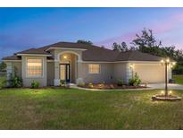 Charming single-story home featuring a well-manicured lawn and inviting curb appeal at dusk at 13741 Sw 73Rd St, Ocala, FL 34481