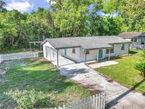 Charming single-story home with a long driveway and a classic white picket fence, showcasing a well-maintained front yard at 1636 Sw 5Th Pl, Ocala, FL 34471