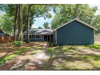 Charming home featuring a blue exterior, lush landscaping, and mature trees for added privacy and curb appeal at 1841 Ne 38Th St, Ocala, FL 34479