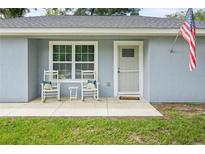 Cozy front porch with rocking chairs, perfect for relaxing and enjoying the outdoors at 2924 Se 142Nd Pl, Summerfield, FL 34491
