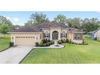 Charming single-story home with a well-manicured lawn and a classic stucco facade at 5024 Sw 114Th Street Rd, Ocala, FL 34476