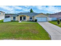 Charming single-story home with a well-maintained lawn and attached two-car garage at 7327 Sw 129Th Ln, Ocala, FL 34473