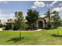 Beautiful home with a well-manicured lawn and inviting entryway with classic architectural columns at 9923 Se 64Th Ave, Belleview, FL 34420
