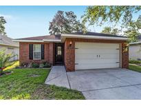 Charming single-story brick home with a well-manicured lawn and a two-car garage at 2127 Ne 38Th Ter, Ocala, FL 34470