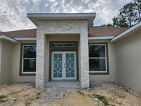 Inviting front entrance featuring double doors and a stone facade, enhancing curb appeal at 2283 Sw 140Th Ct, Ocala, FL 34481