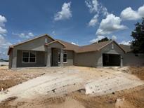 Under-construction single-Gathering home featuring a two-car garage and covered entry at 4370 Nw 1St Ave, Ocala, FL 34475