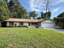 Charming single-story home with a well-maintained lawn and an attached two-car garage at 4701 Ne 9Th St, Ocala, FL 34470