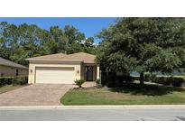 Charming single-story home featuring a brick driveway, attached garage, and well-manicured landscaping at 8303 Sw 78Th Cir, Ocala, FL 34476