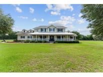 Expansive two-story home with a welcoming front porch and ample lawn space at 9095 Sw 9Th Ter, Ocala, FL 34476