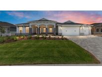 Beautiful one-story home with well-manicured lawn and a three-car garage and stone accents on the columns at 10032 Sw 85Th Place Rd, Ocala, FL 34481