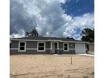 Charming one-story home with a gray exterior, white trim, and a well-manicured lawn at 10385 Se 125Th Ln, Belleview, FL 34420