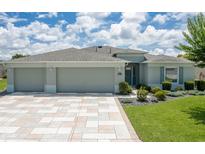 Charming single-story home with a three-car garage, well-maintained lawn, and landscaped garden beds at 16215 Sw 15Th Ct, Ocala, FL 34473
