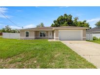 Charming single-story home with a well-maintained lawn and attached two-car garage at 28 Hemlock Radial Loop, Ocala, FL 34472