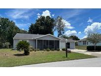 Charming single-story home featuring a screened-in porch, well-manicured lawn, and attached garage at 8650 Sw 108Th Pl, Ocala, FL 34481