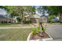 Charming single-story home features a well-manicured lawn, mature trees, and a cozy mailbox area at 949 Woodsong Way, Clermont, FL 34714