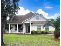 Charming single-Gathering home with a cozy front porch, well-manicured lawn and a beautiful palm tree at 5917 Ne 61St Avenue Rd, Silver Springs, FL 34488