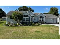 Charming single-story home featuring an attached garage, well-manicured lawn, and tidy landscaping at 8320 Sw 108Th Place Rd, Ocala, FL 34481