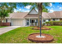 Charming single-story home featuring a garage, a well-manicured lawn, and a welcoming front porch at 8400 Sw 90Th St # C, Ocala, FL 34481