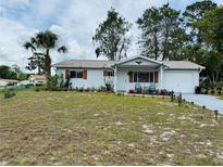 Charming single story home featuring a manicured front yard with mature trees and a driveway at 8547 Sw 106Th Pl, Ocala, FL 34481