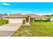 Charming single-story home with a well-maintained lawn, manicured shrubs, and a two-car garage at 10151 Sw 41St Ter, Ocala, FL 34476