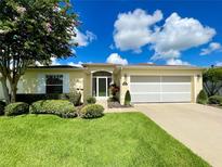 Charming home features a beautiful lawn, flower baskets, and a two-car garage at 15822 Sw 16Th Avenue Rd, Ocala, FL 34473