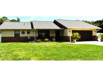 Charming single-story home with a well-maintained lawn, garden, and two-car garage at 2201 Ne 45Th St, Ocala, FL 34479