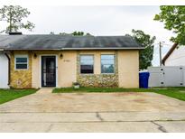 Charming single-story home with stone accents, a well-maintained front yard, and a concrete driveway at 2563 Coral Ave, Kissimmee, FL 34741