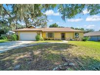 Charming single-story home featuring a manicured lawn, attached garage, and a welcoming stone facade at 3831 Se 48Th St, Ocala, FL 34480