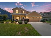 Inviting two-story home featuring manicured lawn, tidy shrubbery, and neutral stucco exterior with an attached two car garage at 4094 Sw 51St Ct, Ocala, FL 34474