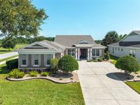 Well-maintained single-story home featuring a manicured lawn, neutral exterior, and concrete driveway at 5093 Nw 35Th Lane Rd, Ocala, FL 34482
